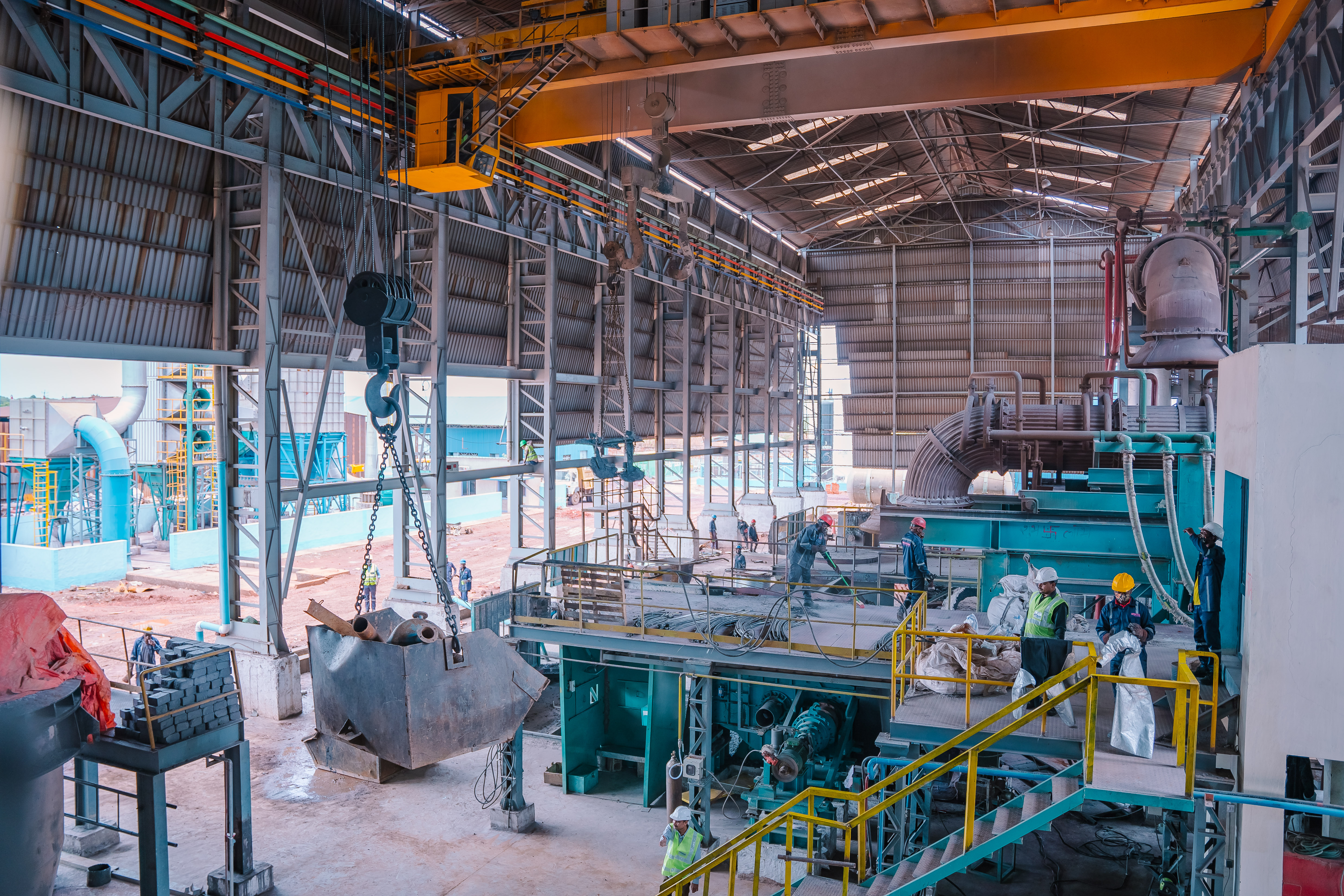 Workers operating machinery inside an industrial facility